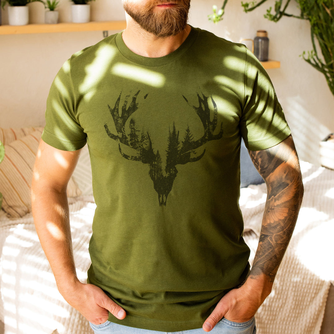 a man wearing a green shirt with a deer head on it