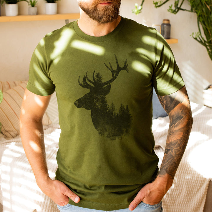 a man wearing a green shirt with a deer on it