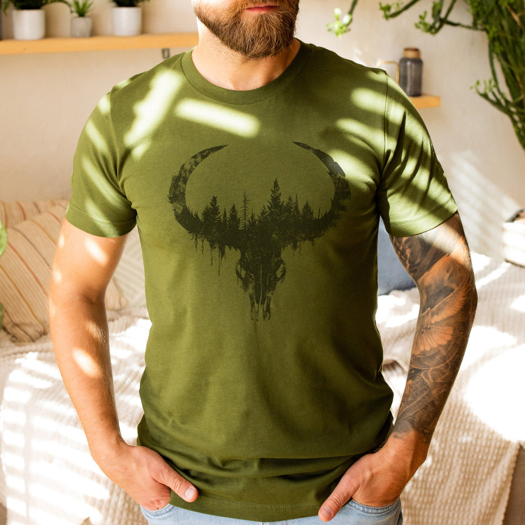 a bearded man wearing a green t - shirt with a deer skull on it